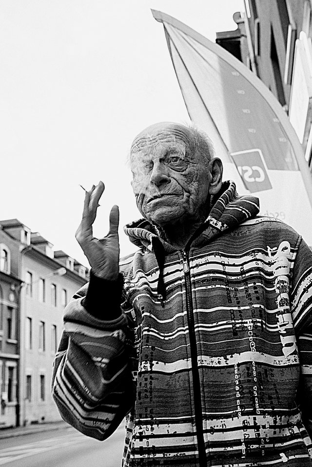 Mann mit Zigarette vor CSv-Wahlplakat in Esch/Alzette