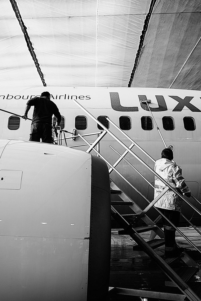 Mitarbeiter waschen im Hangar der Luxair eine Boeing